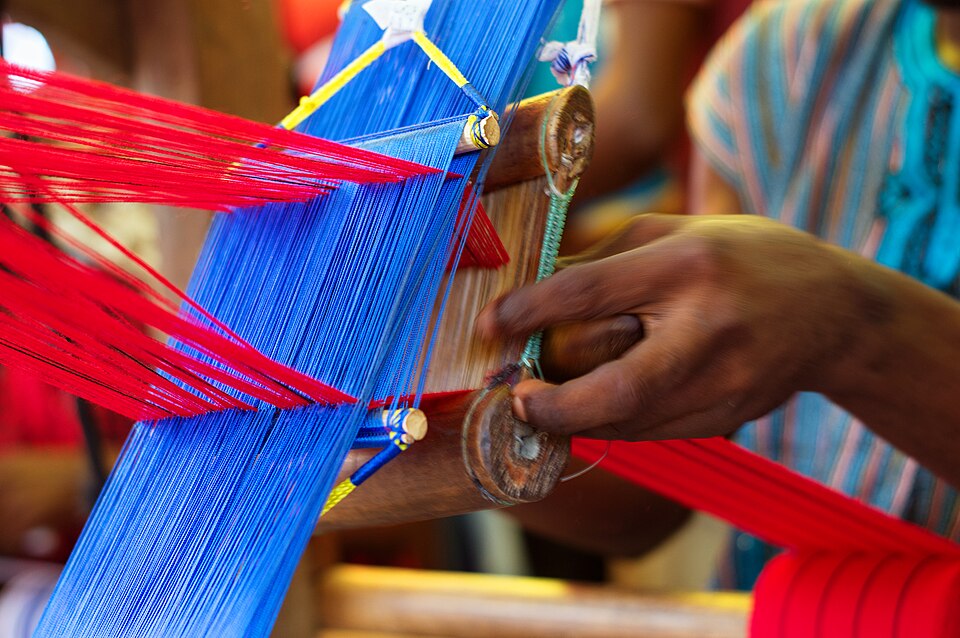 Closeup of traditional strip weaving on hand loom to make kente cloth in northern Ghana